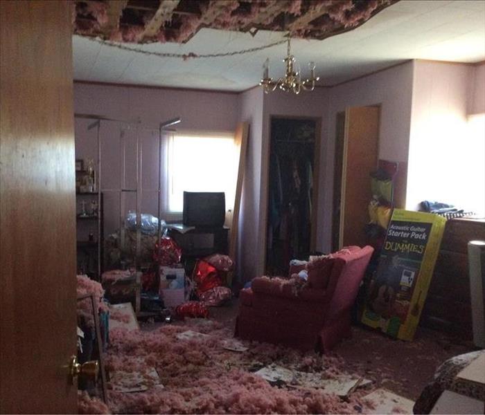 Room filled with falling insulation and ceiling caving in